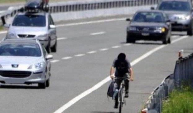 Uomo in biclicletta sull&amp;#039;autostrada
