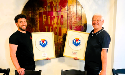 Due uomini con premi in un pizzeria.