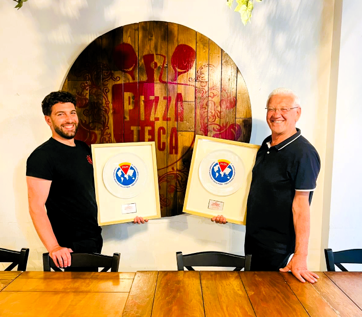 Due uomini con premi in un pizzeria.