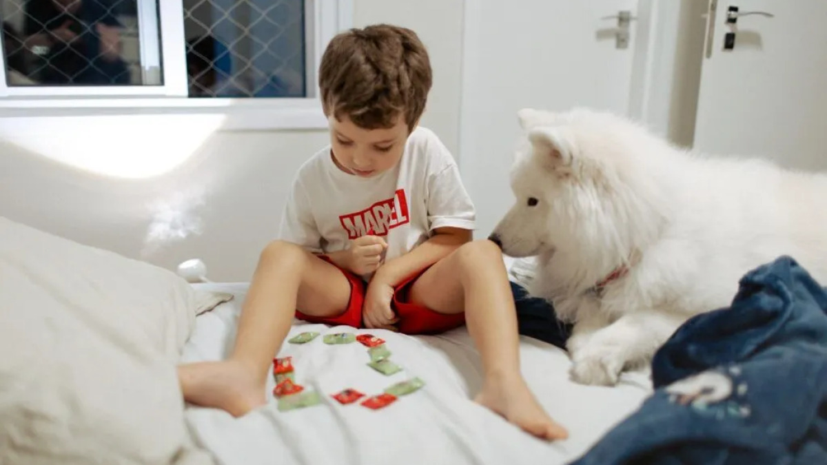 Bambino che gioca con cane - Photo by Helena Lope